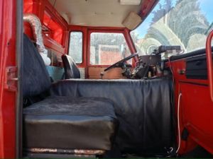 Widok z kabiny w środku – na zdjęciu znajduje się wnętrze kabiny samochodu bojowego strażackiego (siedzenie, kierownica)